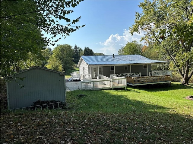 back of property featuring a lawn, a wooden deck, and a storage unit