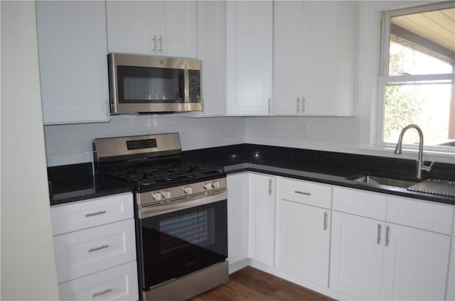 kitchen featuring white cabinets, appliances with stainless steel finishes, dark hardwood / wood-style floors, and sink