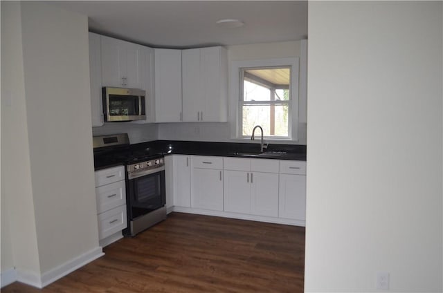 kitchen featuring dark hardwood / wood-style flooring, sink, white cabinets, and appliances with stainless steel finishes