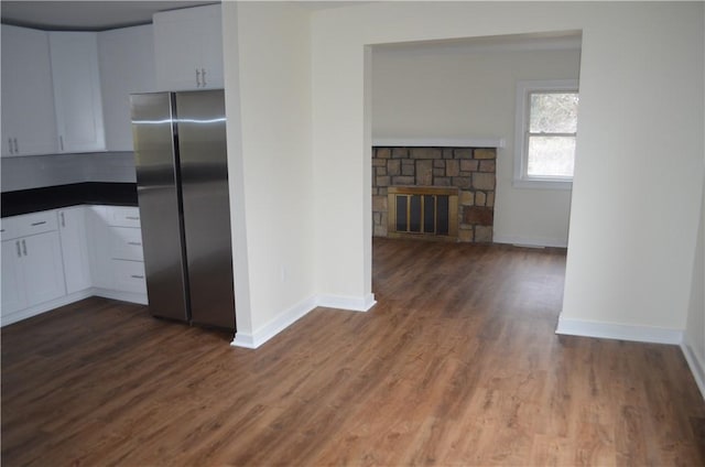 kitchen with stainless steel fridge, white cabinets, and dark wood-type flooring