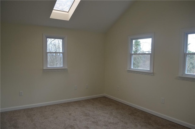 carpeted spare room with lofted ceiling with skylight