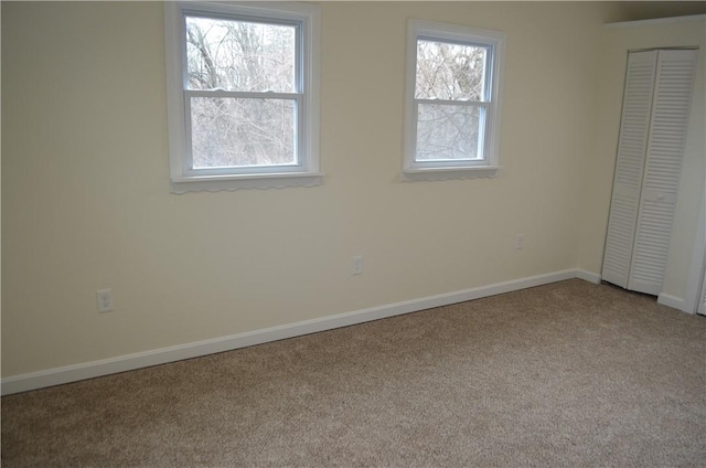 unfurnished bedroom featuring a closet, light colored carpet, and multiple windows