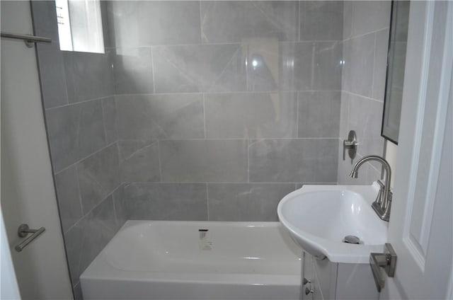 bathroom featuring vanity and tiled shower / bath