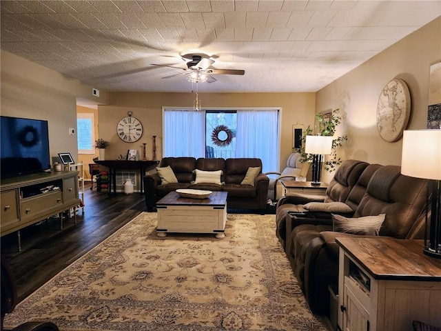 living room with ceiling fan and dark hardwood / wood-style flooring