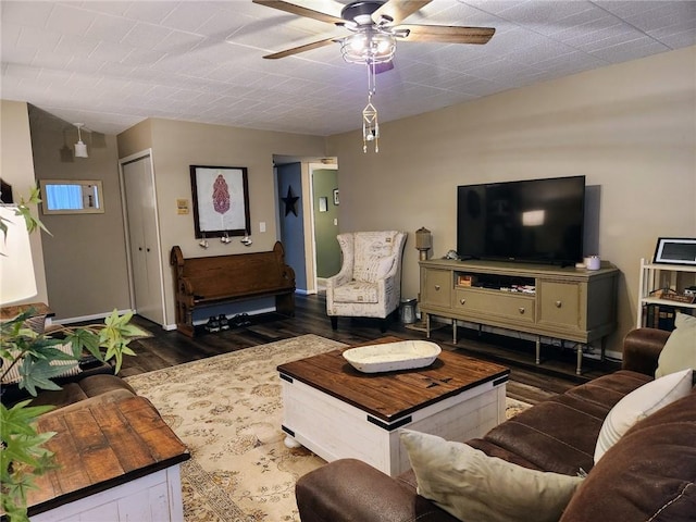 living room featuring ceiling fan and dark hardwood / wood-style floors