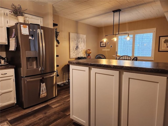 kitchen with white cabinets, stainless steel fridge with ice dispenser, decorative light fixtures, and dark wood-type flooring