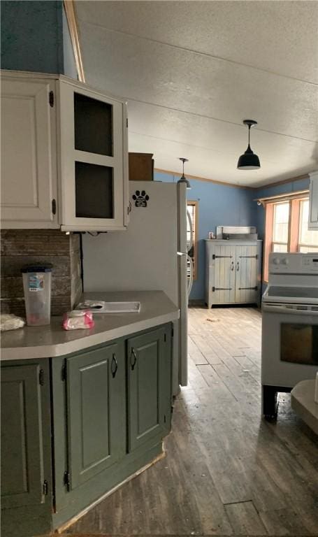 kitchen with white cabinets, light hardwood / wood-style floors, decorative light fixtures, and white electric stove