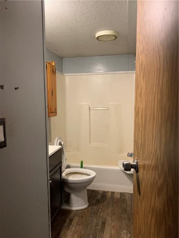 full bathroom with shower / bath combination, wood-type flooring, a textured ceiling, toilet, and vanity