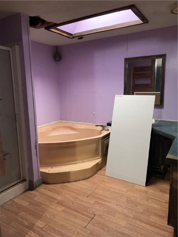 bathroom with a bath and hardwood / wood-style flooring