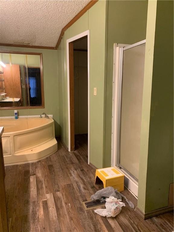 bathroom featuring a textured ceiling, shower with separate bathtub, vaulted ceiling, crown molding, and hardwood / wood-style floors