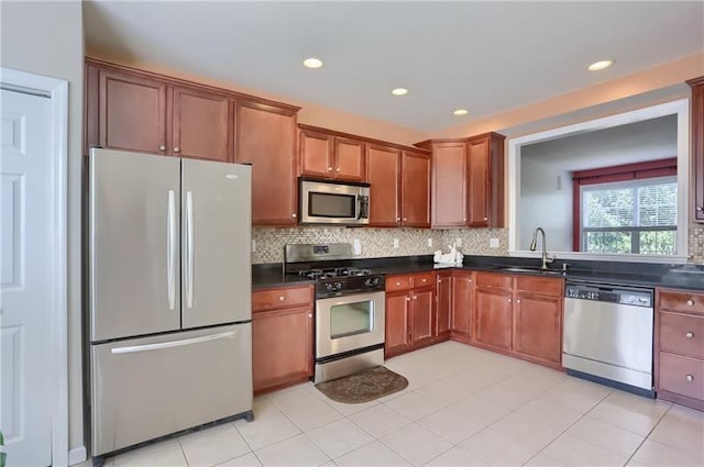 kitchen with decorative backsplash, sink, light tile patterned floors, and stainless steel appliances