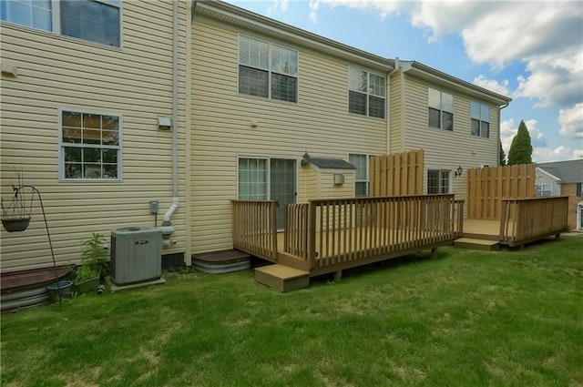 rear view of property with a yard, a deck, and cooling unit