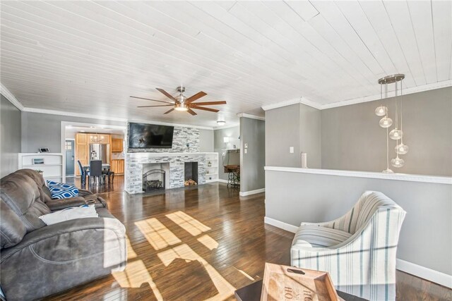 living area with a large fireplace, crown molding, baseboards, and wood finished floors