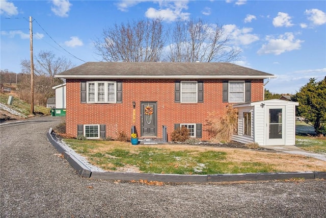 bi-level home featuring a front yard and brick siding