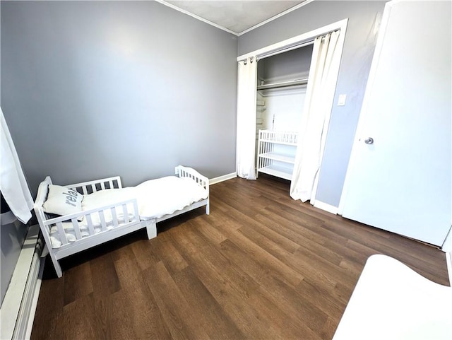 bedroom featuring crown molding, wood finished floors, and baseboards