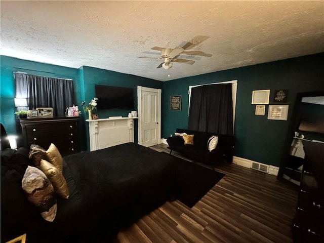 bedroom featuring ceiling fan, dark hardwood / wood-style floors, and a textured ceiling