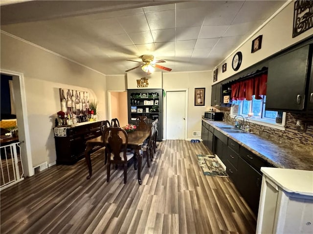 kitchen featuring backsplash, ornamental molding, ceiling fan, sink, and wood-type flooring