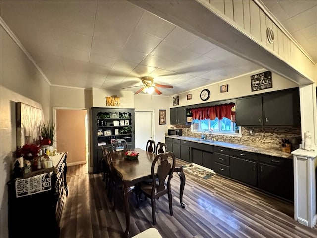 dining area with ceiling fan, sink, crown molding, and dark hardwood / wood-style floors