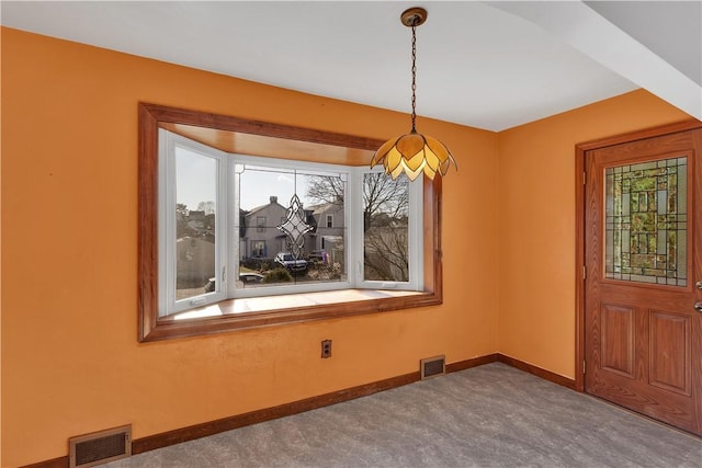 unfurnished dining area featuring carpet and a wealth of natural light