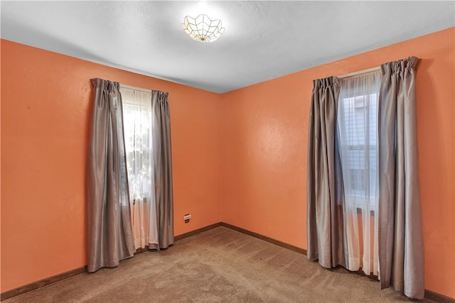 carpeted spare room featuring plenty of natural light