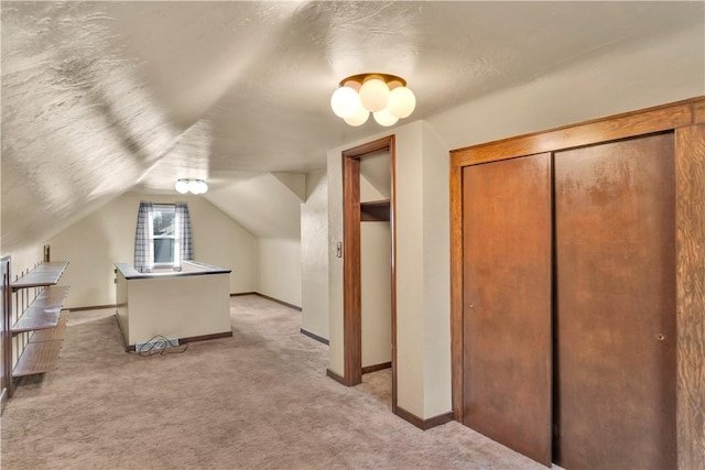 additional living space featuring light carpet and vaulted ceiling