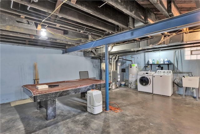 basement featuring sink, washing machine and dryer, water heater, heating unit, and pool table