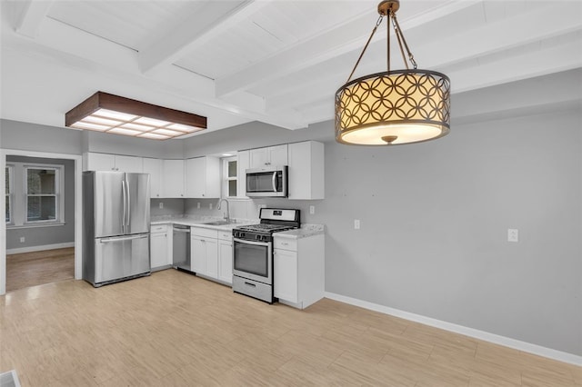 kitchen with hanging light fixtures, sink, appliances with stainless steel finishes, beam ceiling, and white cabinetry