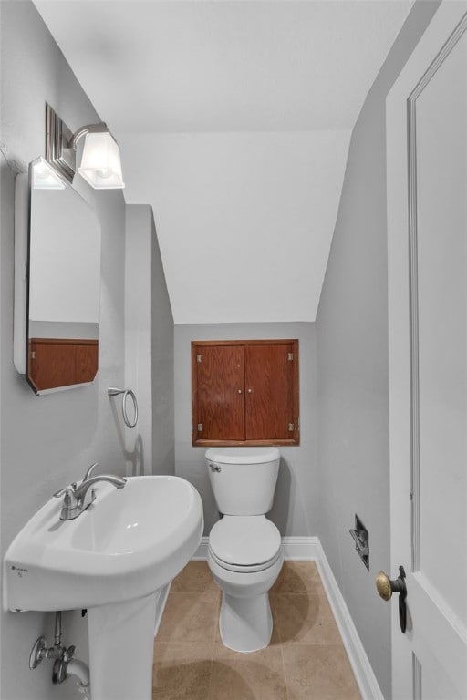 bathroom featuring toilet, tile patterned flooring, and vaulted ceiling