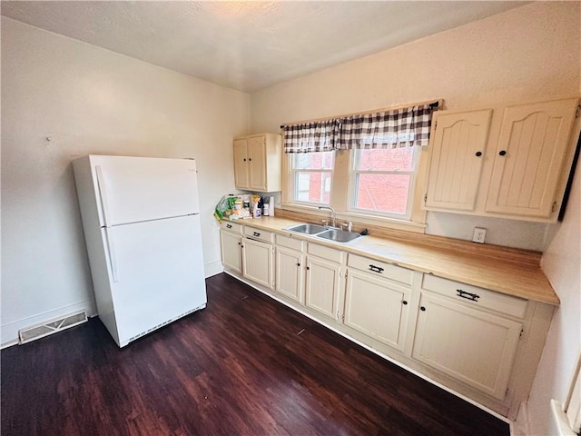 kitchen featuring dark hardwood / wood-style floors, white refrigerator, and sink