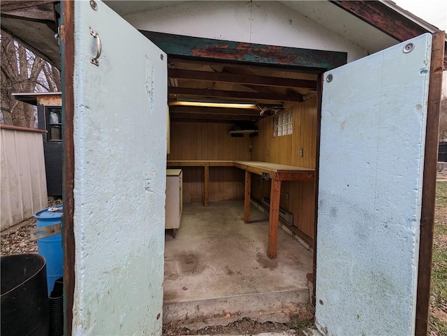 basement featuring a workshop area and wood walls