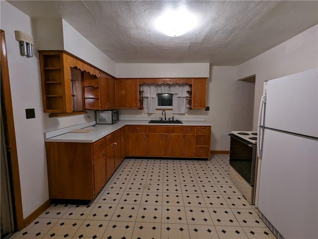 kitchen featuring a textured ceiling, white appliances, and sink