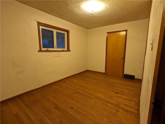 empty room with hardwood / wood-style flooring