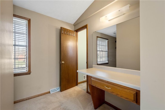 bathroom with vanity, a wealth of natural light, and vaulted ceiling