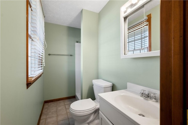 bathroom featuring tile patterned flooring, a textured ceiling, vanity, and toilet