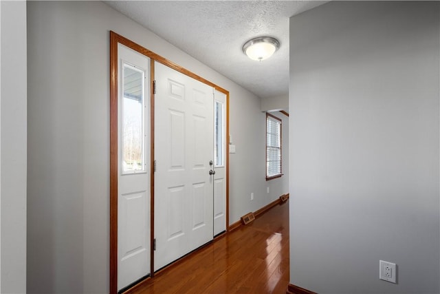 foyer entrance with wood-type flooring and a textured ceiling