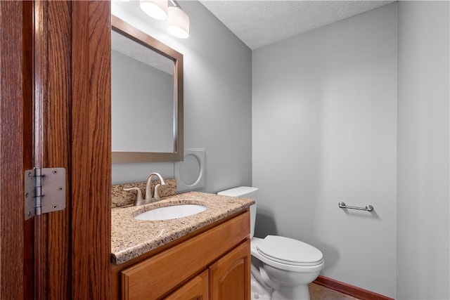 bathroom with vanity, a textured ceiling, and toilet