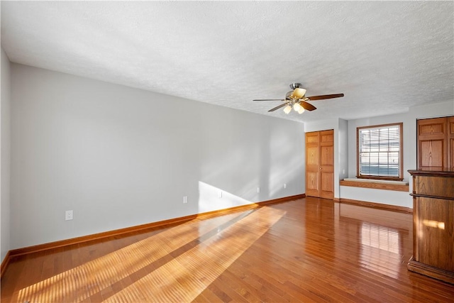 unfurnished living room featuring ceiling fan, wood-type flooring, and a textured ceiling