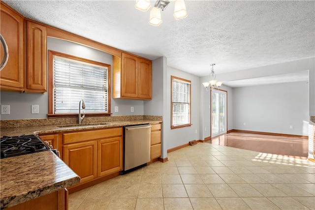 kitchen featuring pendant lighting, plenty of natural light, stainless steel appliances, and an inviting chandelier