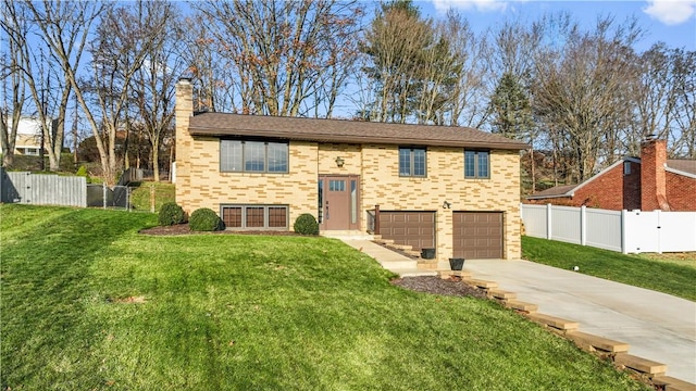 bi-level home with a garage and a front lawn