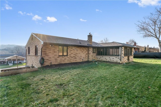 back of house featuring a sunroom and a yard