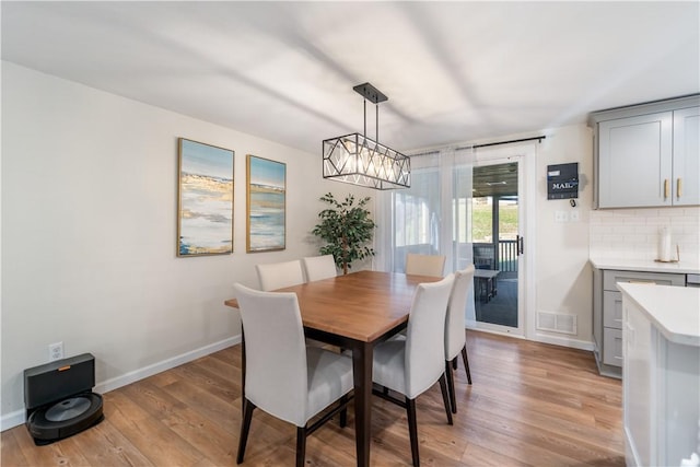 dining space with light wood-type flooring and a chandelier