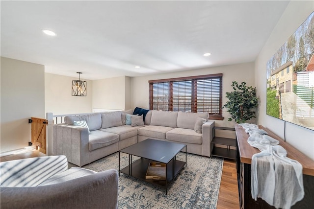 living room featuring a notable chandelier, light hardwood / wood-style floors, and a wealth of natural light