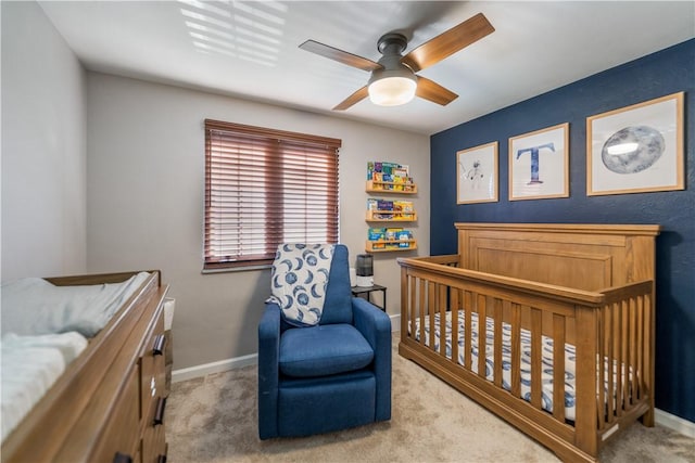 bedroom featuring a crib, carpet floors, and ceiling fan