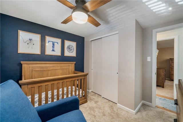 carpeted bedroom featuring ceiling fan and a closet