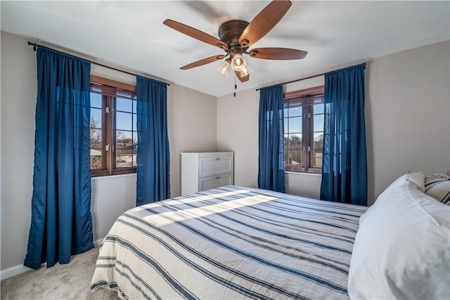 carpeted bedroom with multiple windows and ceiling fan