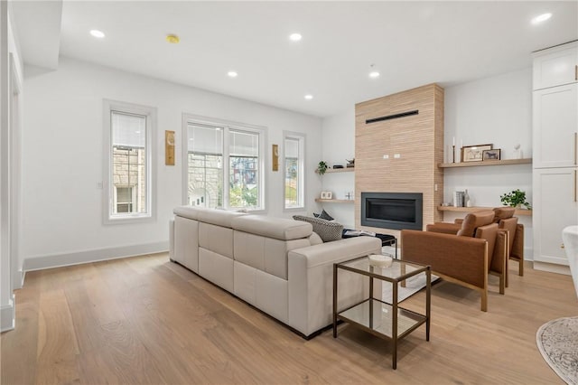 living room with a fireplace and light wood-type flooring