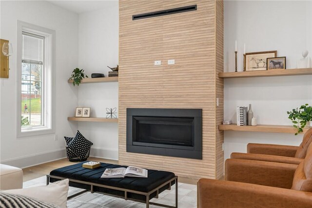 living room with a fireplace and light wood-type flooring