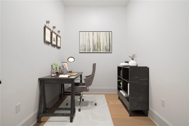 home office with light hardwood / wood-style floors