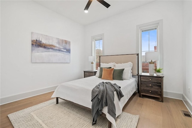 bedroom with multiple windows, ceiling fan, and light hardwood / wood-style flooring