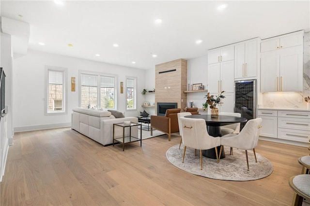 dining room featuring a fireplace and light hardwood / wood-style flooring